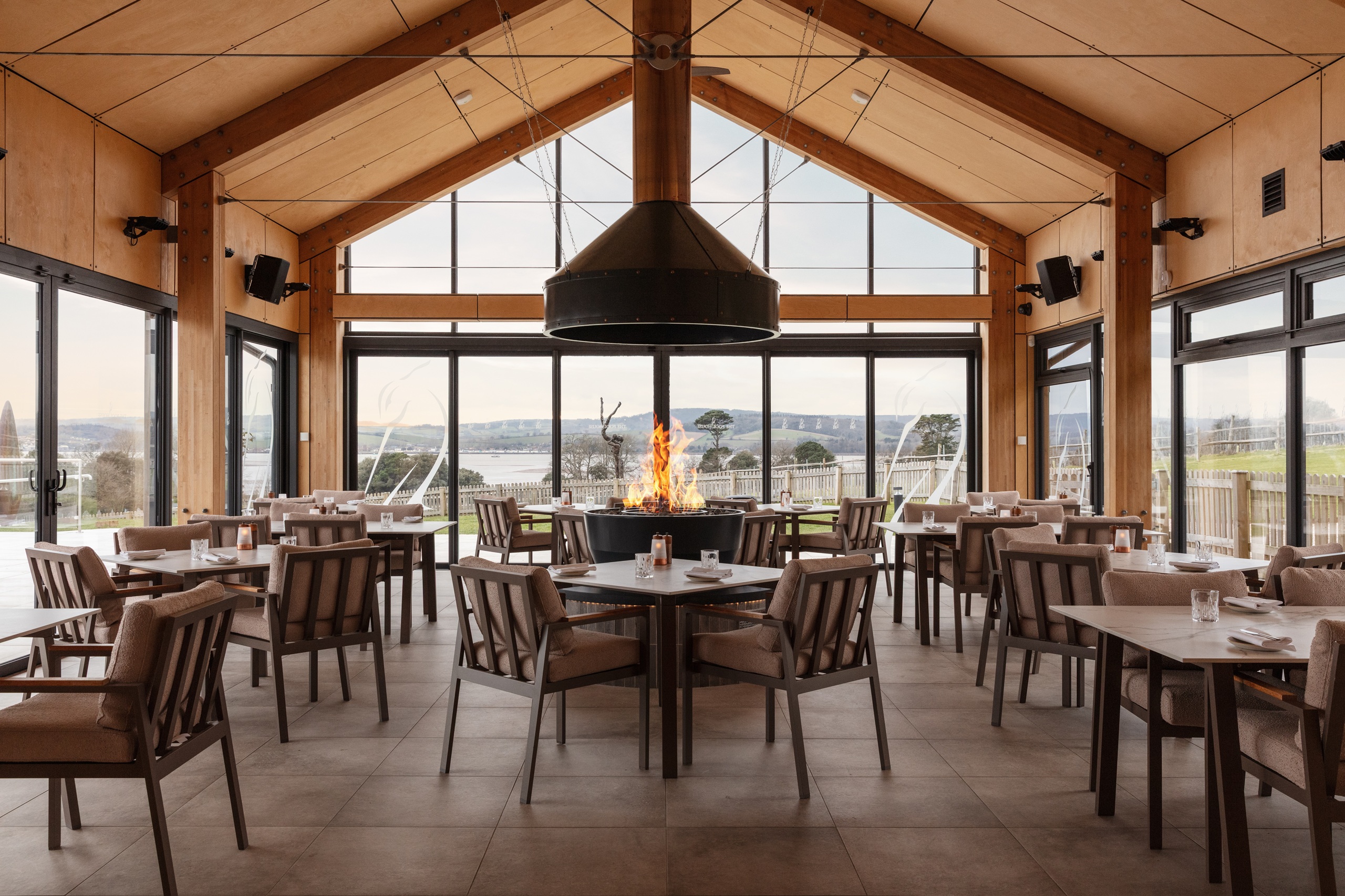 Pool House Restaurant and Bar at Lympstone Manor with central open fire feature and view out to the vineyard and Exe estuary